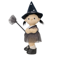 Toy doll dressed as a witch with a broom on a white background