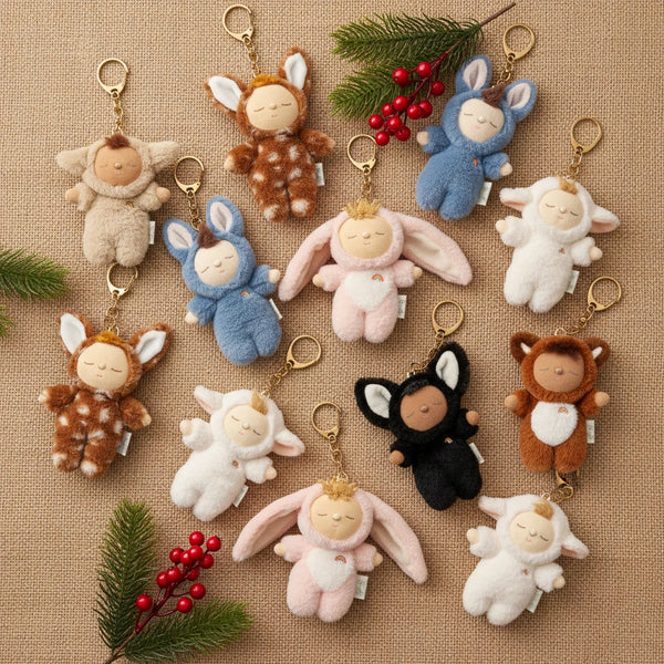 Collection of small animal plush keychains on a textured surface with decorative elements.