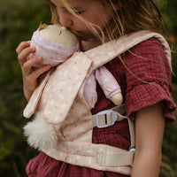 This soft, easter-themed pink doll carrier features adjustable straps and a snug fit, ideal for kids to tote their dolls comfortably. Perfect bunny-themed doll accessory, plush carrier for toddlers.