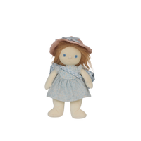 Stuffed doll with a pink hat and blue dress on a white background
