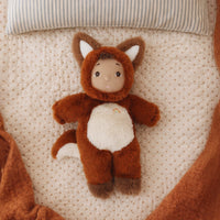 Plush toy fox lying on a textured surface