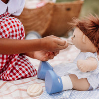 Child playing with a doll on a checkered blanket