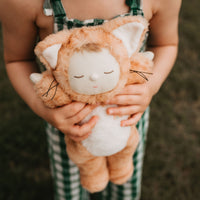 Little girl playing with ginger tabby cat, soft plush toy doll for kids