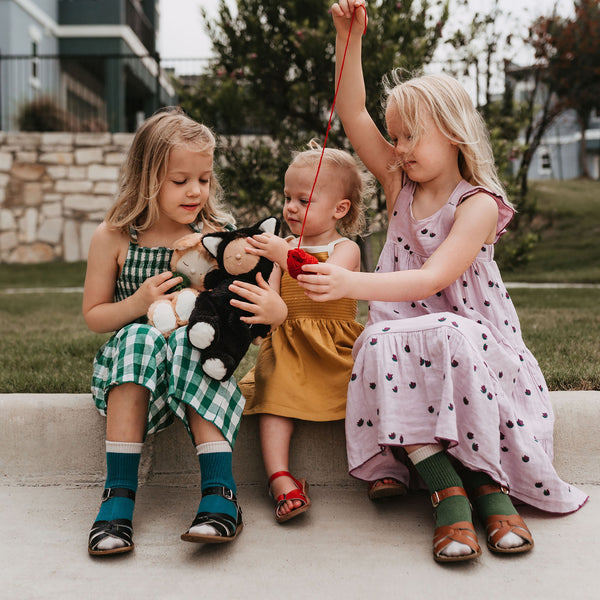 3 little girls playing with a black cat, soft plush toy for kids