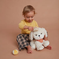 Olli Ella Dinkum Dog Starter Set - ball, bandana and brush kit with child using on Cookie