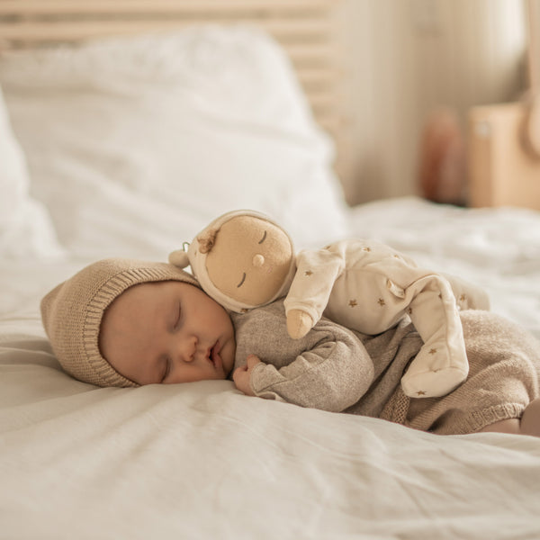 Posable plush doll suitable from birth. The Lullaby Lyra includes a pompom on their bonnet that plays a sleepy tune when pulled. 