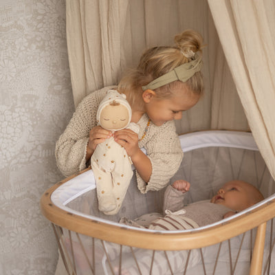 Beautiful plush doll, posable and perfectly weighted for calm. The Lullaby Lyra includes a pompom on their bonnet that plays a sleepy tune when pulled. This doll is suitable from birth.