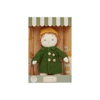 Stuffed toy with a green coat and yellow hat in packaging