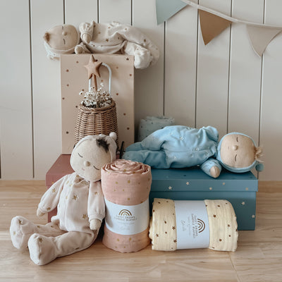 Keepsake gift set featuring a beautiful pink blue doll and matching swaddle cloth. The lullaby Leo includes a pompom on their bonnet that plays a sleepy tune when pulled, perfect for soothing newborns, making it the perfect gift for newborns and expecting parents.