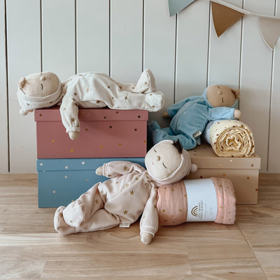 Keepsake gift set featuring a beautiful soft doll and matching swaddle cloth. The lullaby Lyra includes a pompom on their bonnet that plays a sleepy tune when pulled, perfect for soothing newborns, making it the perfect gift for newborns and expecting parents.
