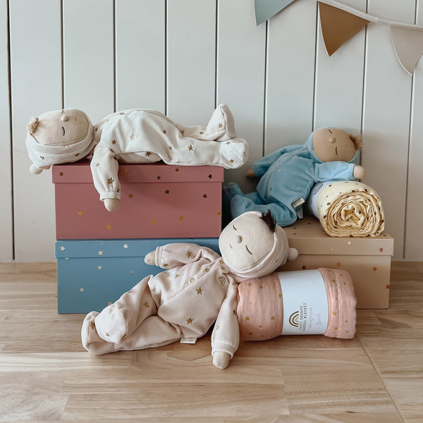 Keepsake gift set featuring a beautiful soft doll and matching swaddle cloth. The lullaby Lyra includes a pompom on their bonnet that plays a sleepy tune when pulled, perfect for soothing newborns, making it the perfect gift for newborns and expecting parents.