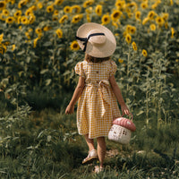 Olli Ella Rattan Mushroom Basket - pink musk and white coloured in field of sunflowers