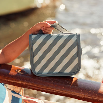 Compact, durable kids blue striped toiletry bag by Olli Ella. Perfect for toiletries and travel essentials. Ideal for organized packing, made from eco-friendly materials.