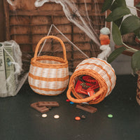 Olli Ella Halloween Berry Basket with orange stripe holding Halloween treats