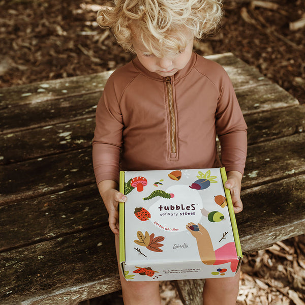 Olli Ella Tubbles Sensory Stones Garden Goodies packaging with child